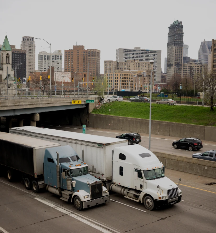 Two TOP Worldwide semi trucks in Detroit showcasing full truckload (FTL) shipping solutions for reliable freight transportation.