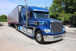 TOP Worldwide semi truck on the highway, representing the transportation backbone of LTL pricing and freight cost strategies.