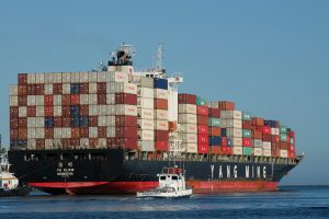 TOP Worldwide cargo ship loaded with containers at sea, illustrating ocean freight strategies to reduce shipping costs and optimize logistics.