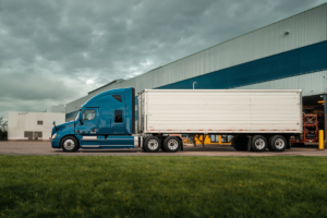 Semi-truck leaving distribution center at dawn representing rising freight rates and changing logistics market conditions in 2026