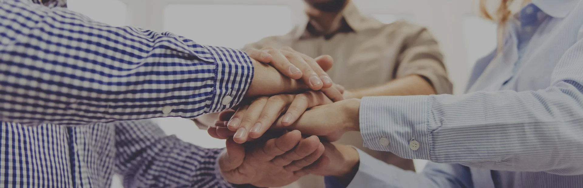 Hands stacked together representing teamwork, collaboration, and career opportunities at TOP Worldwide.